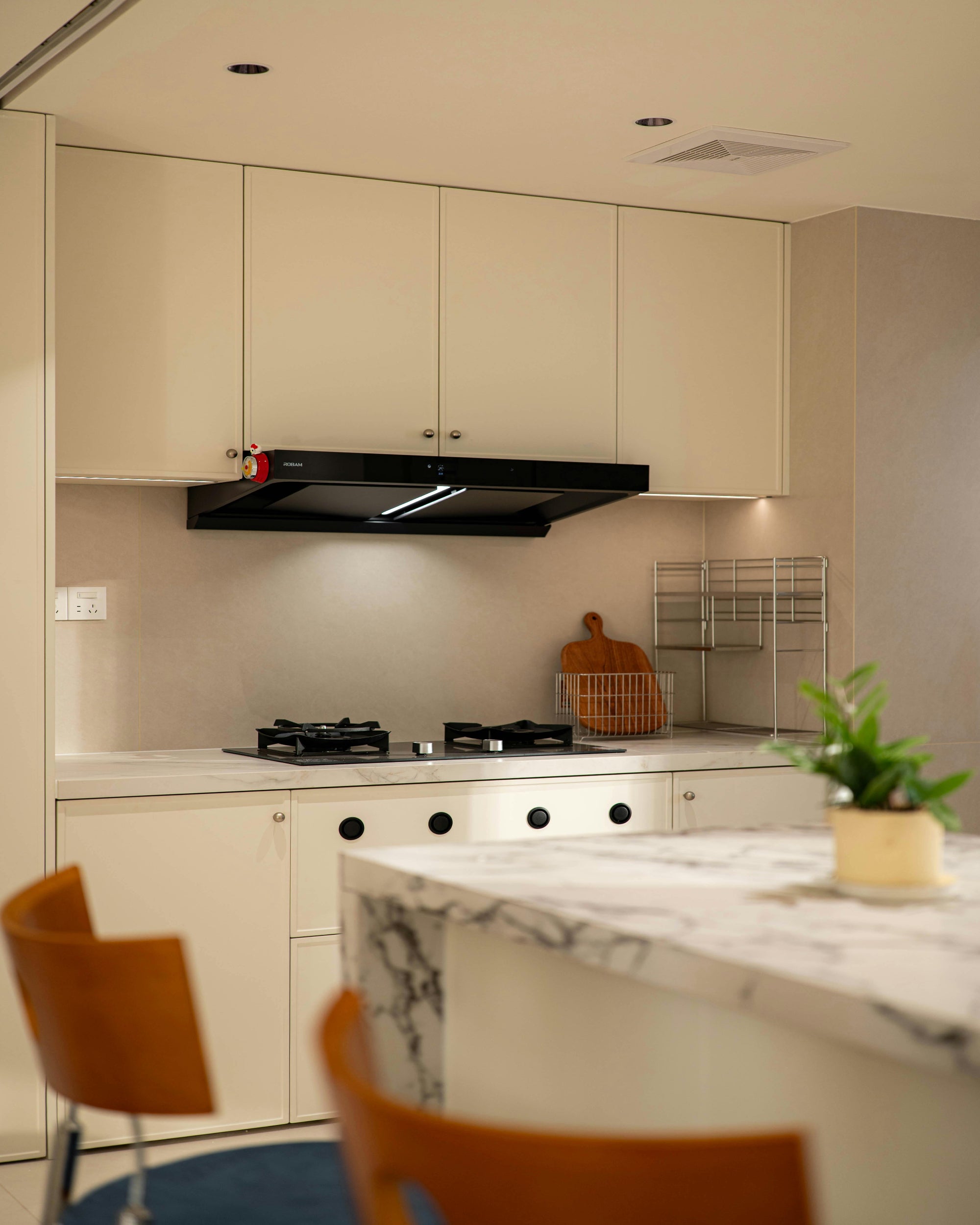 Modern kitchen with marble island, gas stove, and cabinets.